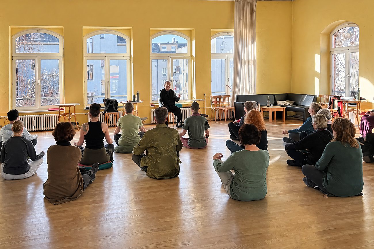 Qi-Gong-Kurs in Radebeul: Übende sitzen im Kreis in einem hellen Saal, vorn Horst-Rainer Rust