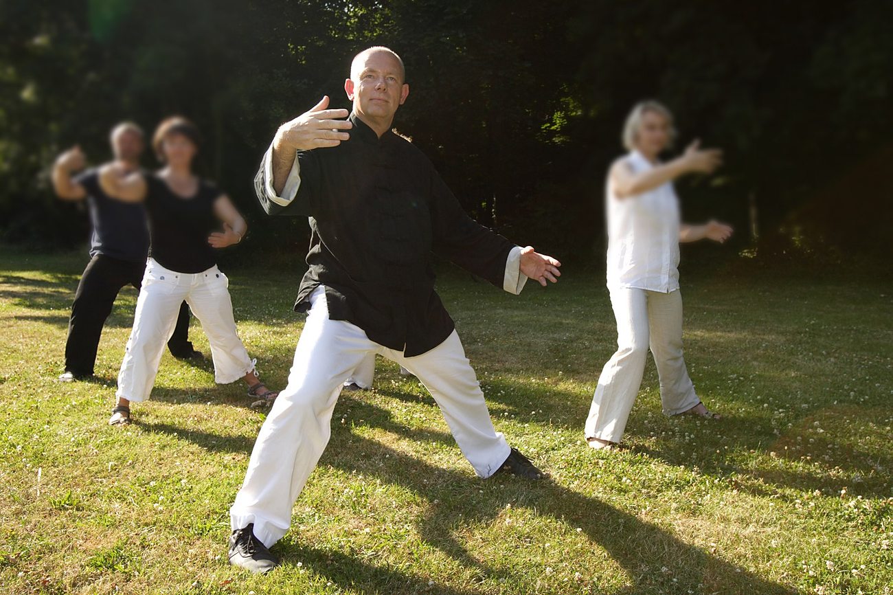 Kursgruppe übt Qi Gong mit Horst-Rainer Rust im Grünen