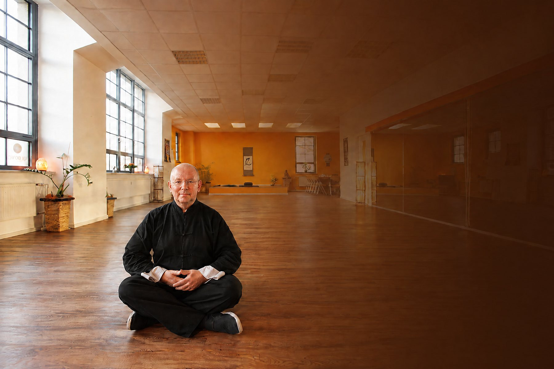 Horst-Rainer Rust sitzt allein im hellen Qi-Gong-Übungsraum