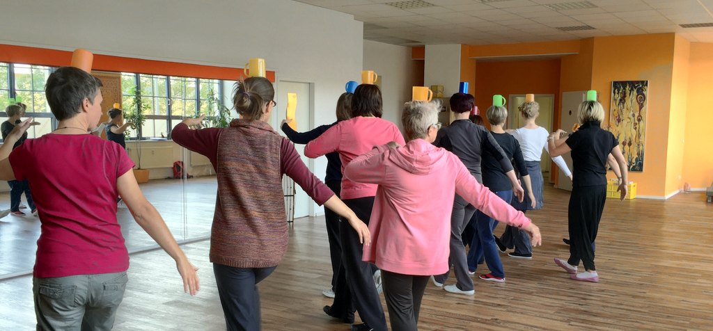 Qi-Gong-Kurs: spielerische Gleichgewichtsübung mit Bechern